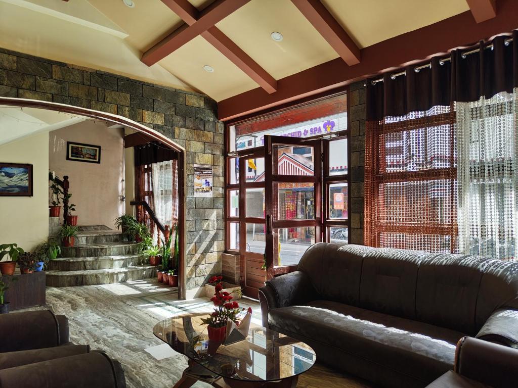 una sala de estar con un sofá y una mesa en Hotel The Narayani Continental, en Gangtok