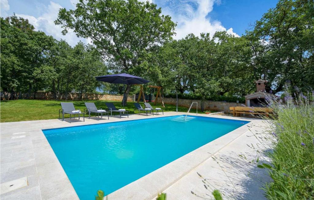 - une piscine avec des chaises et un parasol dans l'établissement Casa Ana Tripari, à Višnjan