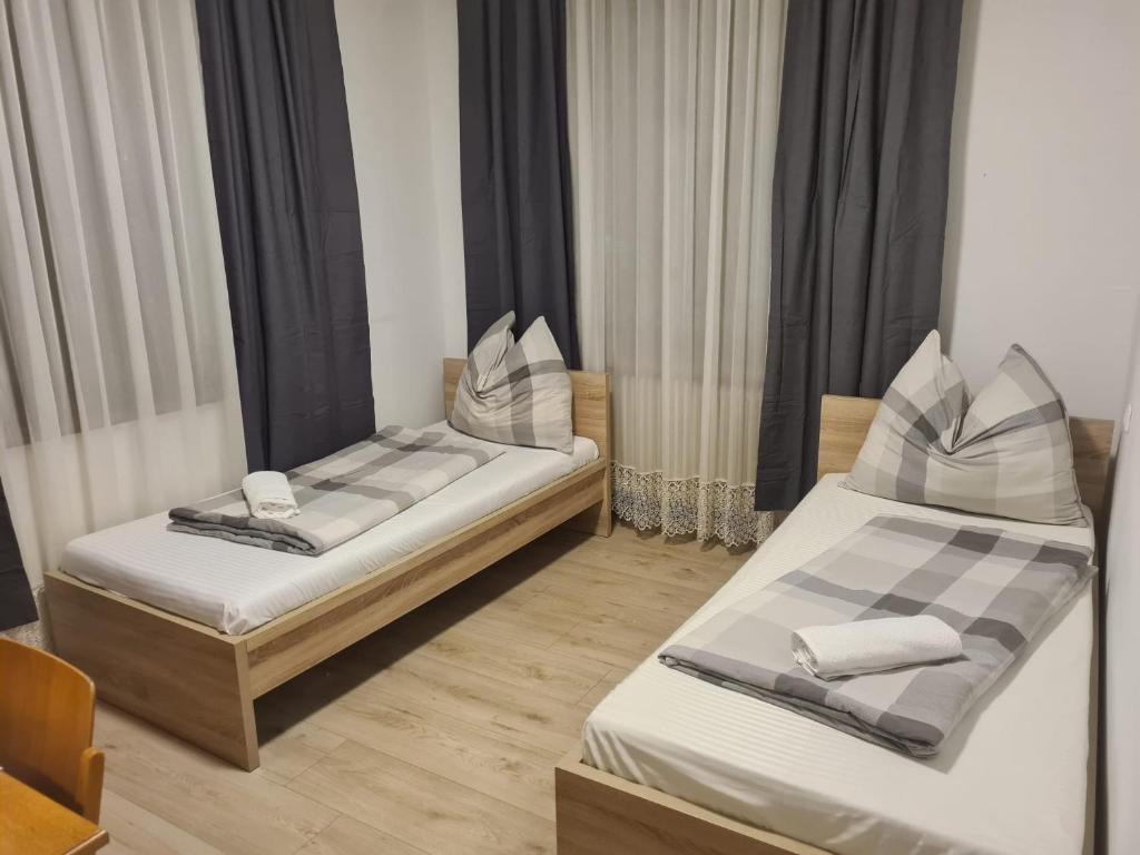 two twin beds in a room with curtains at Toskana Zimmer in Schwanenstadt