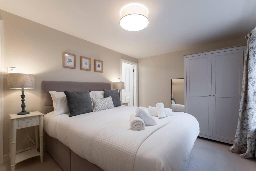 una camera da letto con un grande letto bianco con asciugamani di Cosy & Peaceful Self Contained Home in Montpellier a Cheltenham