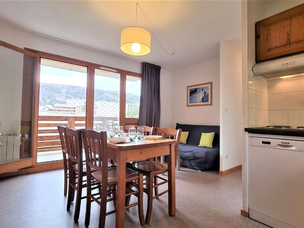 une cuisine et une salle à manger avec une table et des chaises dans l'établissement T2 Cabine, 6 pers, proche pistes, parking, casier à ski - FR-1-525-268, à Saint-Étienne-en-Dévoluy