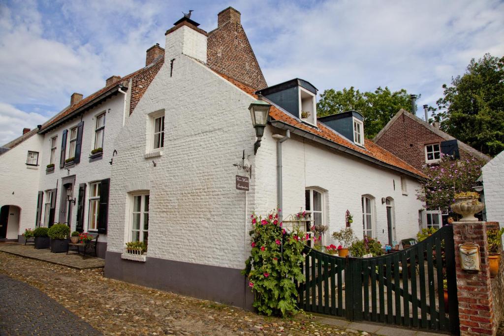 uma casa branca com uma cerca à frente. em Het Molenaarshuis em Thorn