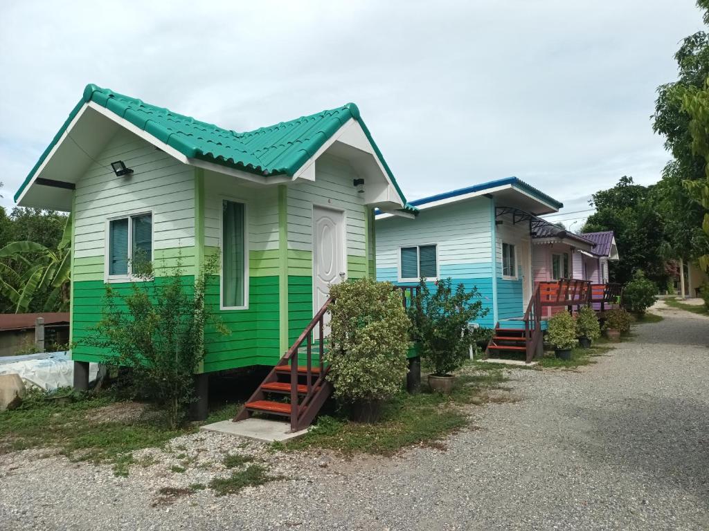 a green and white house with a green roof at ชายเขาโฮมสเตย์ in Kanchanaburi City