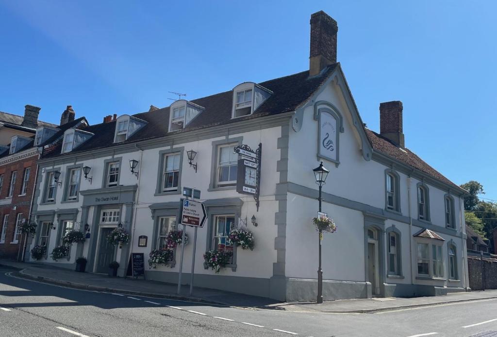 a white building on the corner of a street at The Swan Hotel, Alresford in Winchester