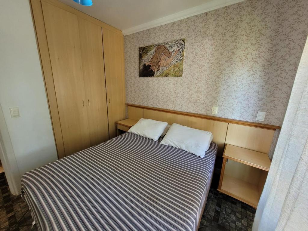 1 dormitorio pequeño con 1 cama y una foto en la pared en Apartamento Lexus Beira Mar - apt 101, en Florianópolis