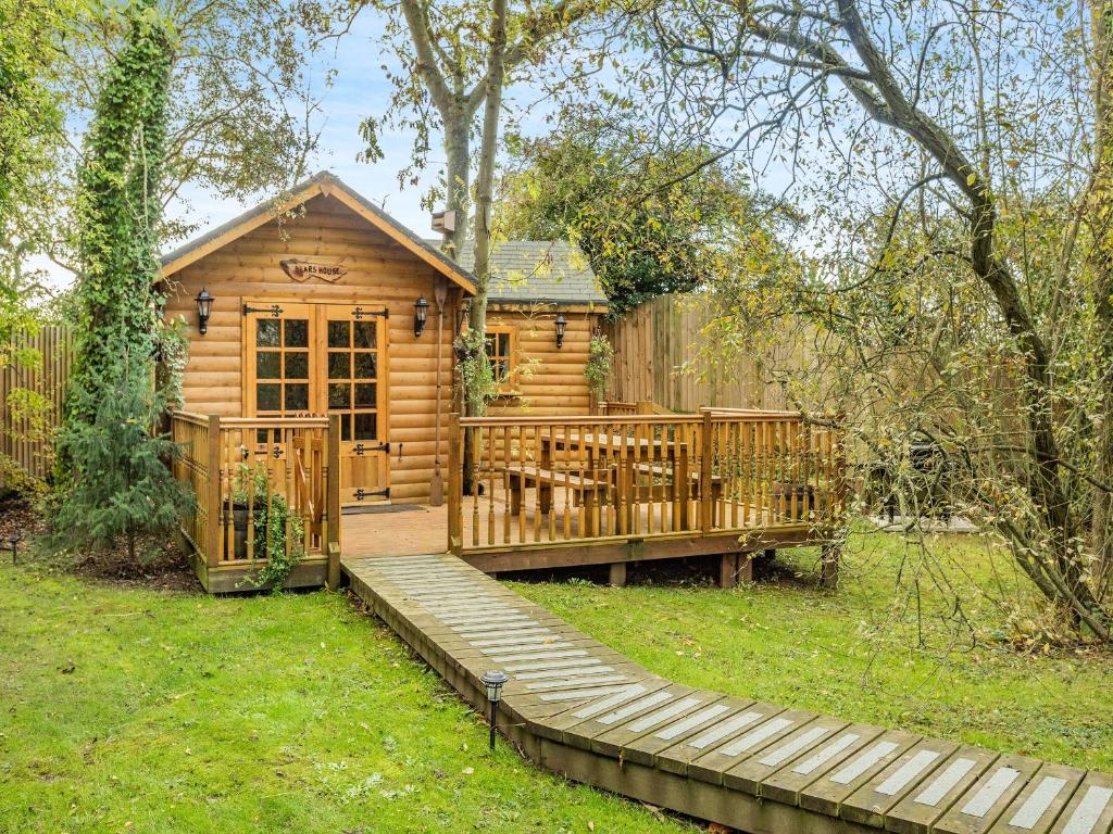 a wooden cabin with a wooden walkway in the yard at Bear House- Uk45704 in Brinkley