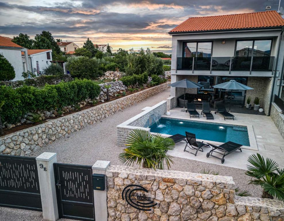 a home with a swimming pool and a house at Villa More in Krk