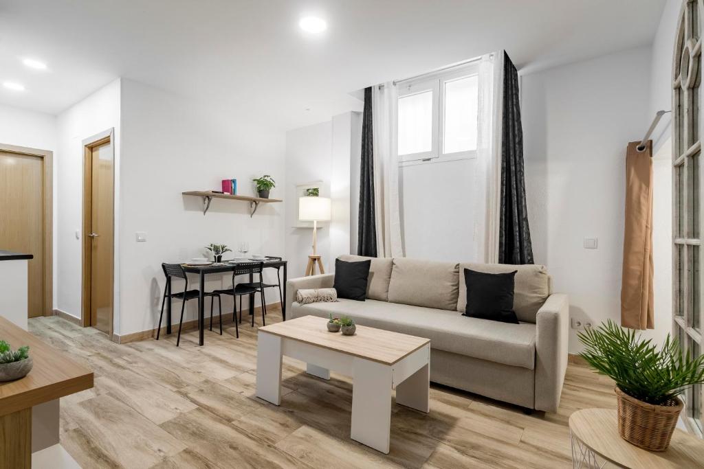 ein Wohnzimmer mit einem Sofa und einem Tisch in der Unterkunft Charming Madrid Numancia in Madrid