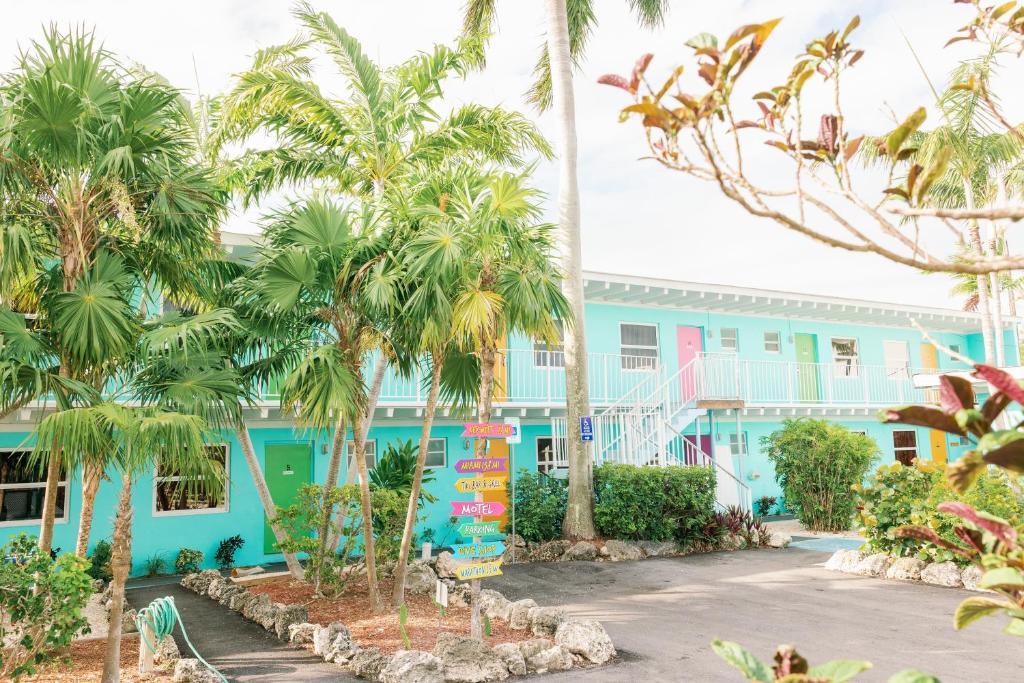 a blue building with palm trees in front of it at Looe Key Reef Resort and Dive Center in Summerland Key