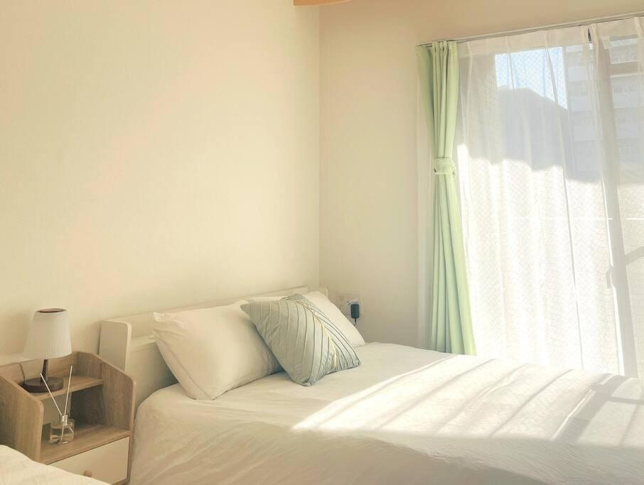 a white bedroom with a bed and a window at Dotonbori, Nipponbashi, Nagahoribashi Station 5minutes on foot Double bed SE7 in Osaka