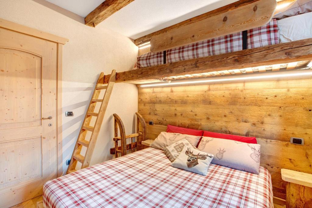 1 dormitorio con 1 cama y 1 litera en Casa Clus apartments Bormio 1 en Valdisotto