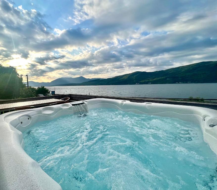 グレンコーにあるGlenachulish Bay with Hot Tubの- 水の景色を望むホットタブ