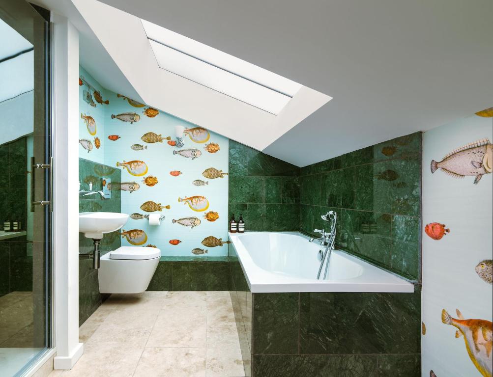 La salle de bains est pourvue de toilettes, d'un lavabo et d'une baignoire. dans l'établissement Lux Mews House Portobello 4 bed, à Londres