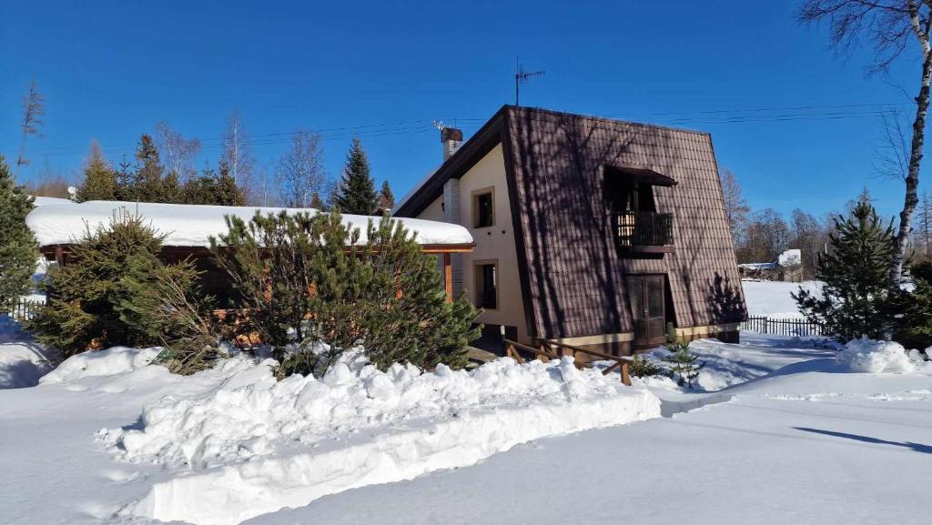 a house covered in snow with a pile of snow at Chata Anna in Nižné Hágy