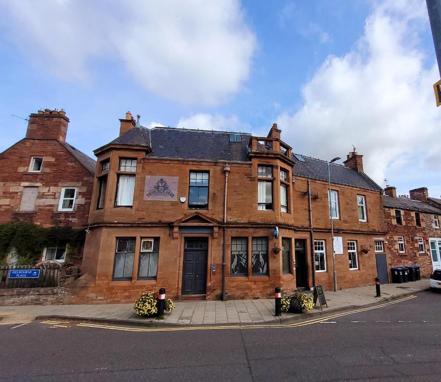 an old brick building on the corner of a street at Dryburgh Arms Pub with Rooms in Melrose