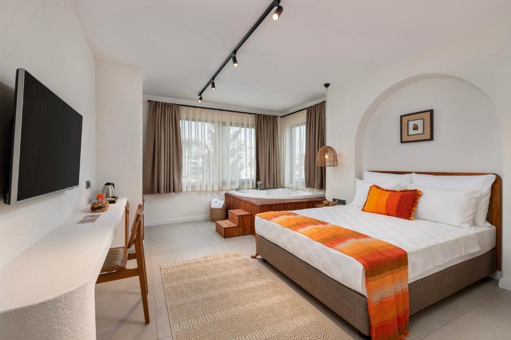 a hotel room with a bed and a desk and a television at Azuu Boutique Hotel in Antalya