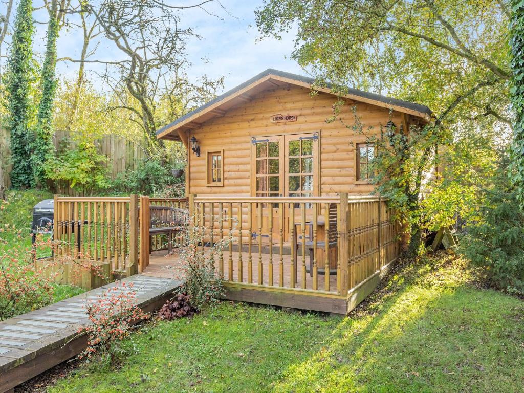 a small wooden cabin with a wooden fence at Lion House- Uk45705 in Brinkley