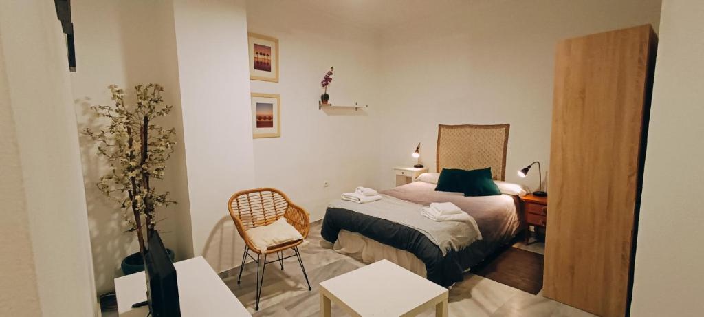 1 dormitorio pequeño con 1 cama y 1 silla en Santos, en Málaga