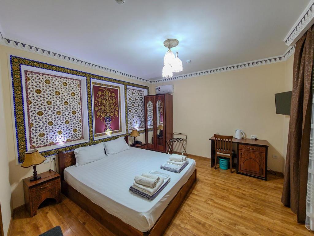 - une chambre avec un lit et un bureau dans l'établissement Old House Hotel, à Boukhara