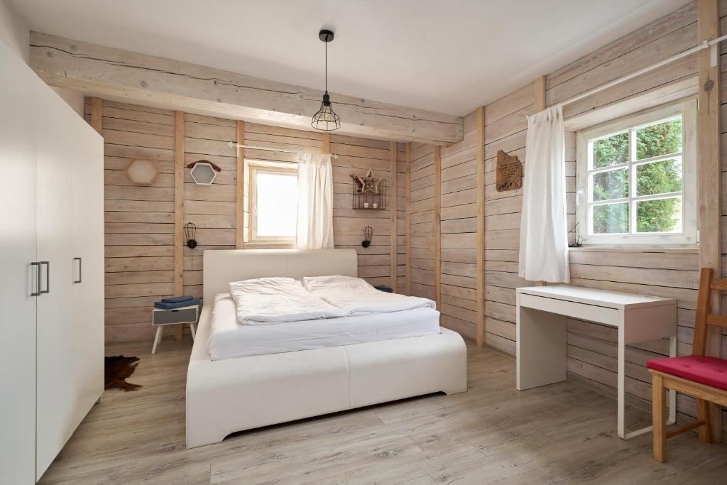 a bedroom with a white bed and a desk at Apartament Empujon Sokołowsko in Sokołowsko