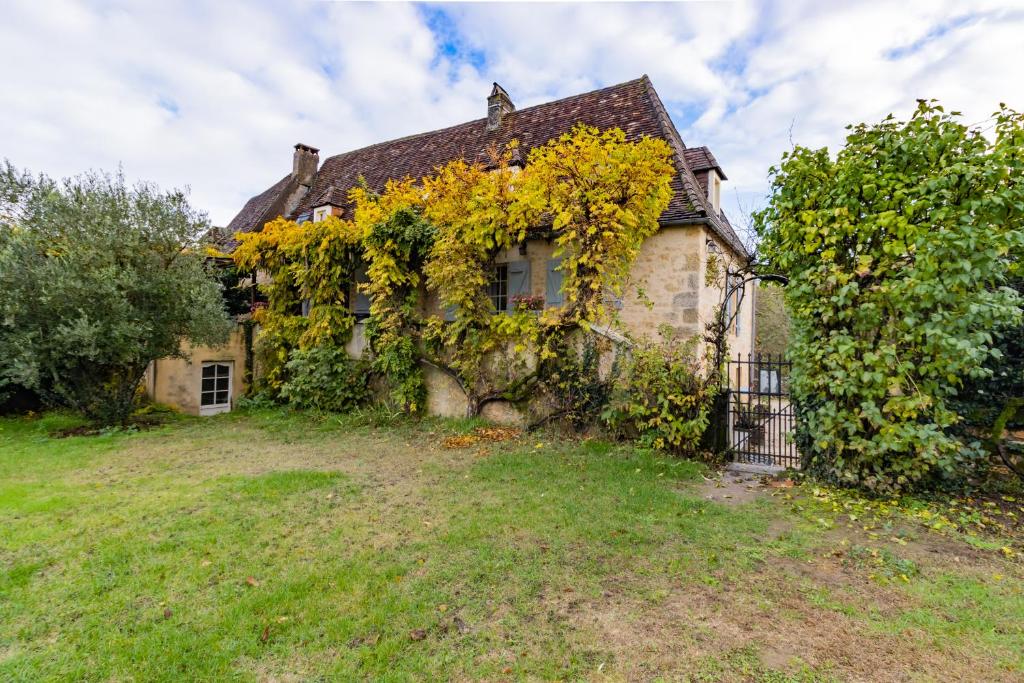 stary dom z bluszczem na boku w obiekcie Gite Castelnaud w mieście Sainte-Mondane