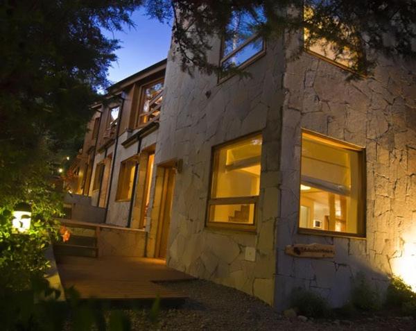 un edificio de piedra con ventanas iluminadas por la noche en Manke Apart & Suites en San Martín de los Andes