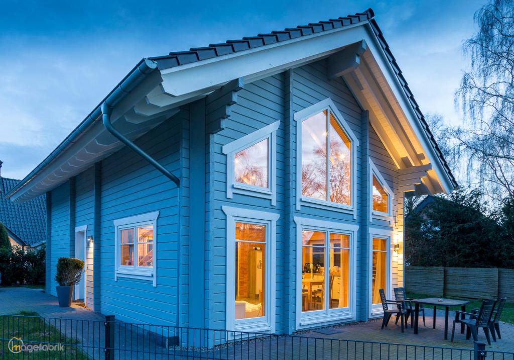 a blue house with white windows and a table at Ferienhaus Nordic in Lembruch