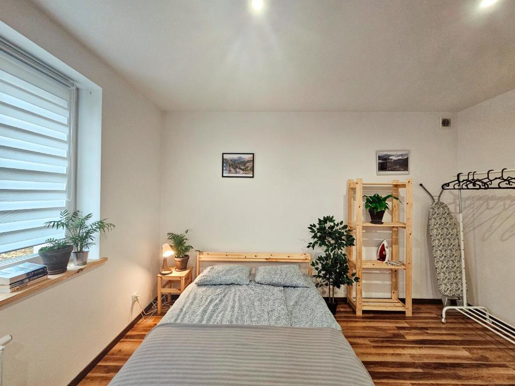 Schlafzimmer mit einem Bett und einem Fenster in der Unterkunft Apartament 5 minut od Parku Zamkowego in Pless