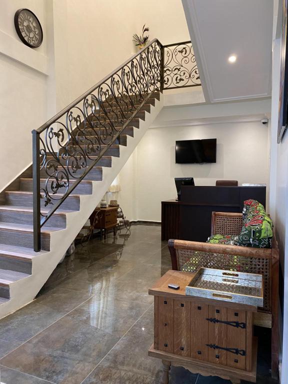 een trap in een woonkamer met een bank en een tafel bij EAGLE VAULT (THE NEST FACILITY) in Accra