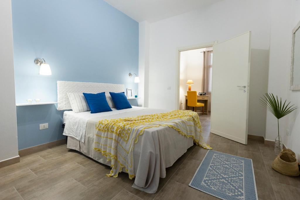 a bedroom with a large bed with blue pillows at My Sicily Home - Casa con giardino in Salemi