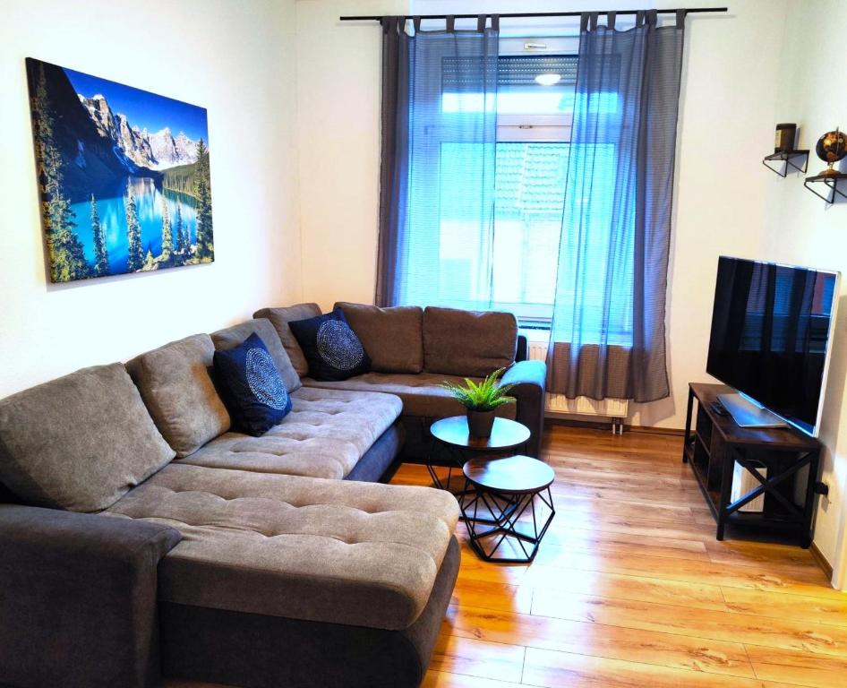 - un salon avec un canapé et une télévision dans l'établissement City Appartement Mönchengladbach, à Mönchengladbach