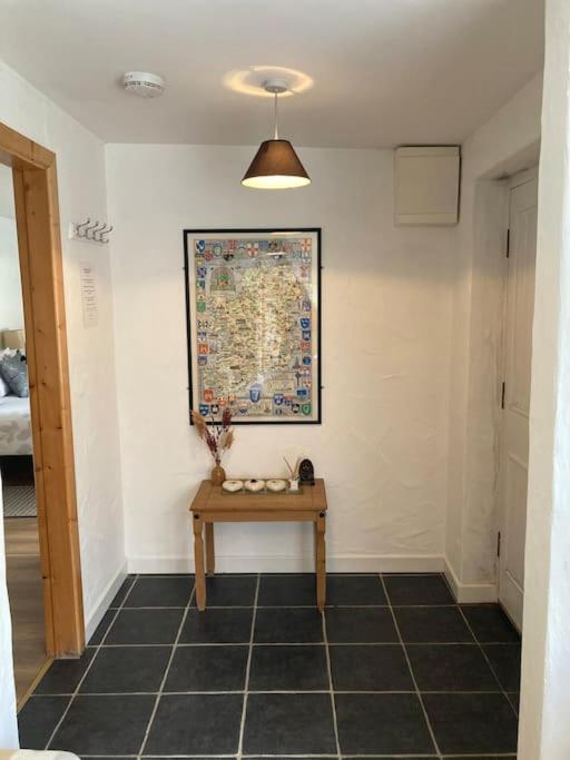 a hallway with a table and a painting on the wall at The Potters Cottage in Clifden