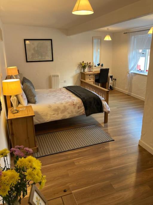 a bedroom with a bed and a desk with a desk at The Potters Cottage in Clifden