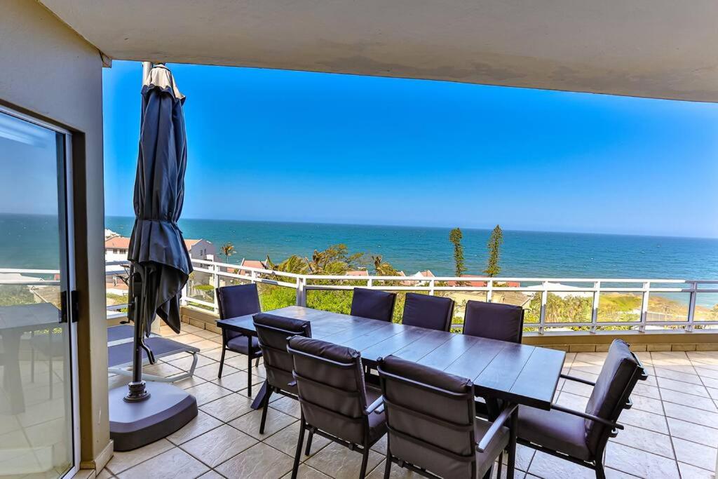 a patio with a table and chairs and the ocean at Les Dauphine 3 - Premier Beach Front Apartment in Ballito