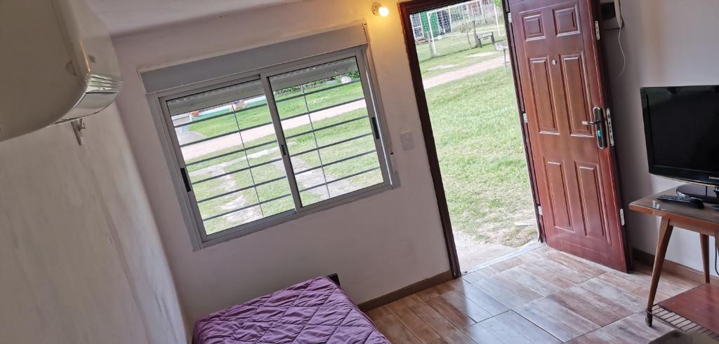 a room with a door and a window and a television at La Isla - Araminda in Araminda
