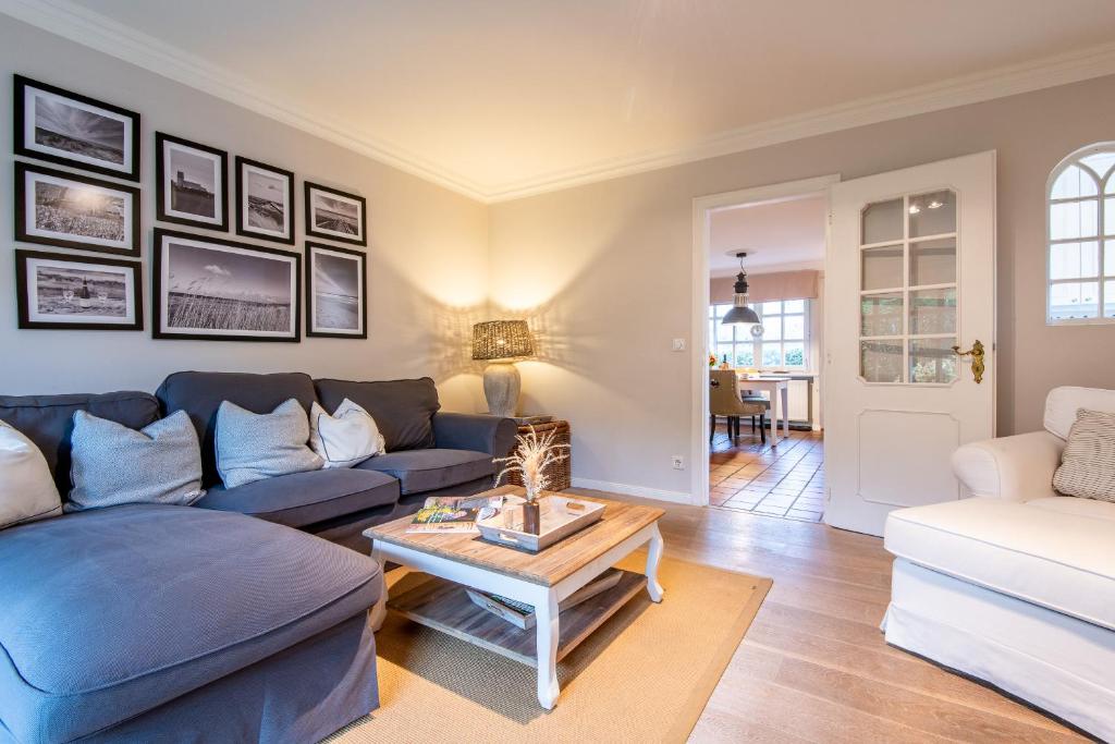 a living room with a blue couch and a table at Haus Alster Whg 1 in Keitum