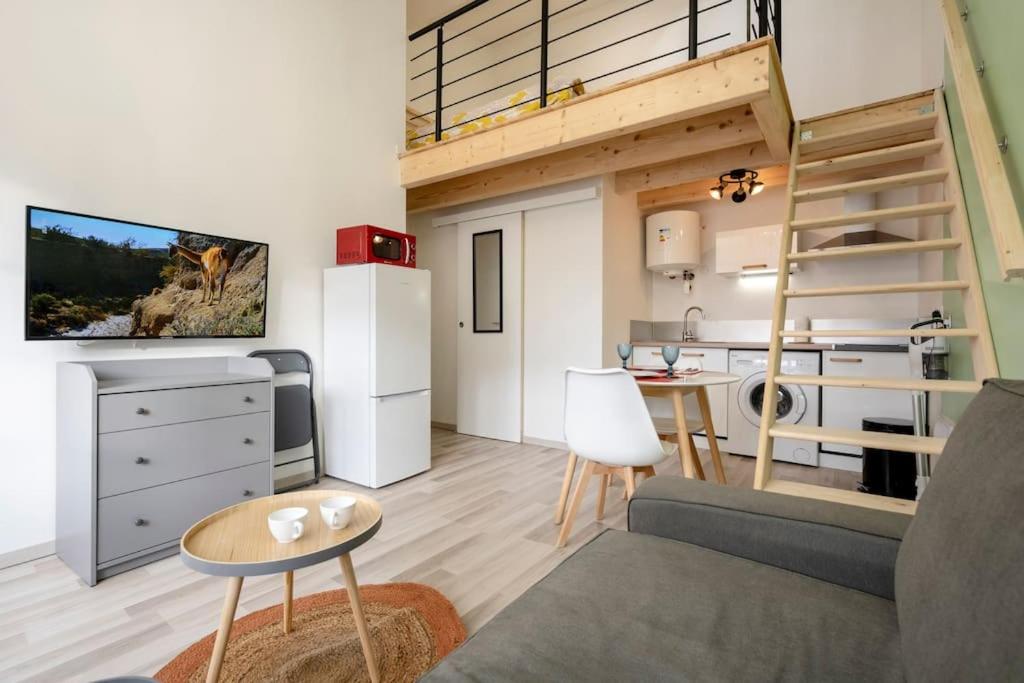 a small living room with a staircase in a tiny apartment at Studio mezzanine "chaumiane" proche de la gare in Issoire