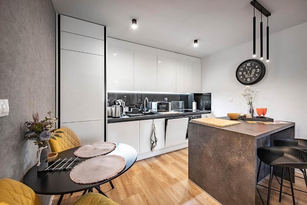 a kitchen with white cabinets and a table and chairs at Apartments Centrum Hviezdoslav in Poprad