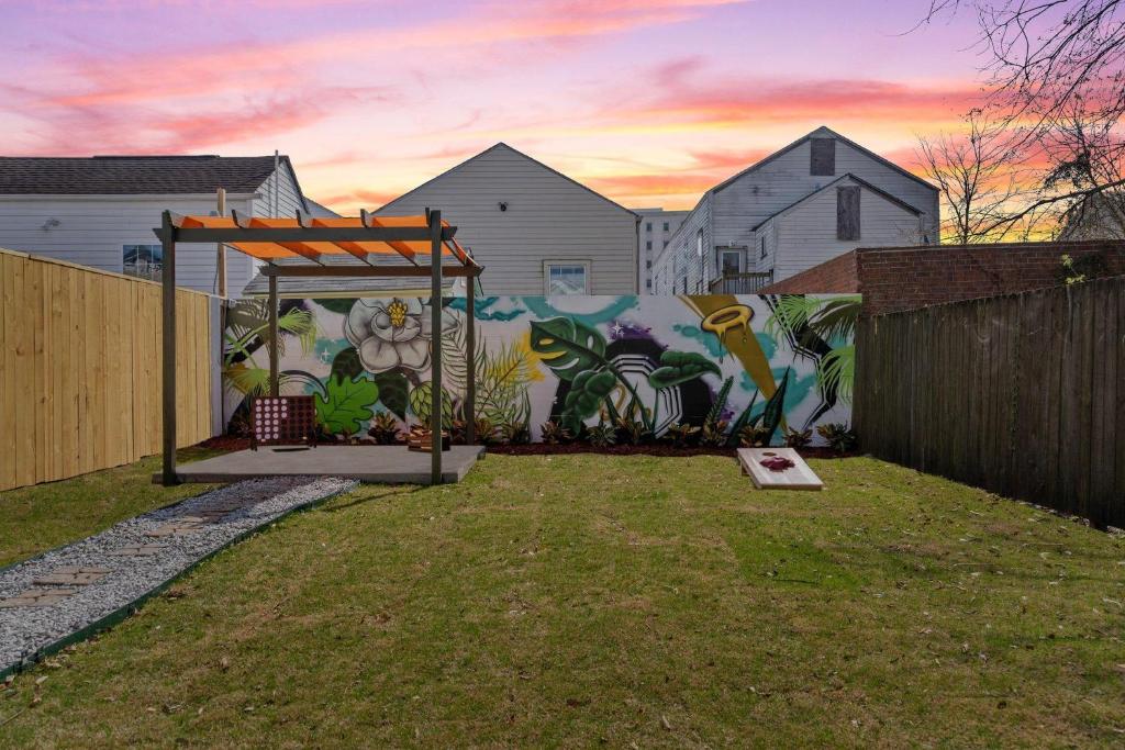 a mural on a wall in a backyard with a gazebo at House Of Vibes in New Orleans