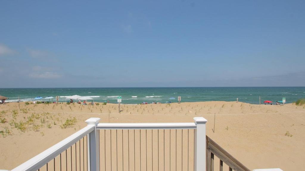 een strand met een wit hek en de oceaan bij OCEANFRONT, Ocean Views, Beach Access, Close to Shopping, KH123, Pelican's Watch in Kitty Hawk