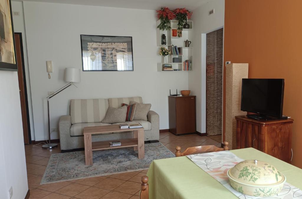 a living room with a couch and a tv at L'angolo di Anna in Pieve di Soligo