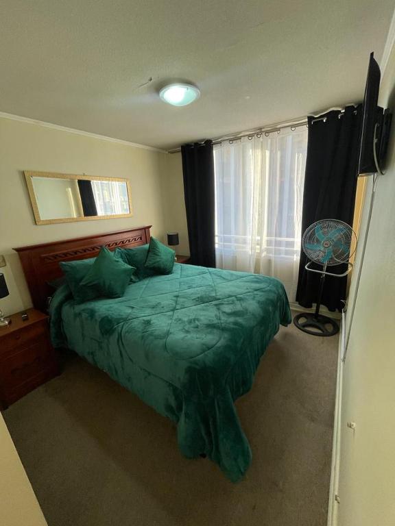 um quarto com uma cama verde e uma janela em alojamiento 3 dormitorios em Santiago