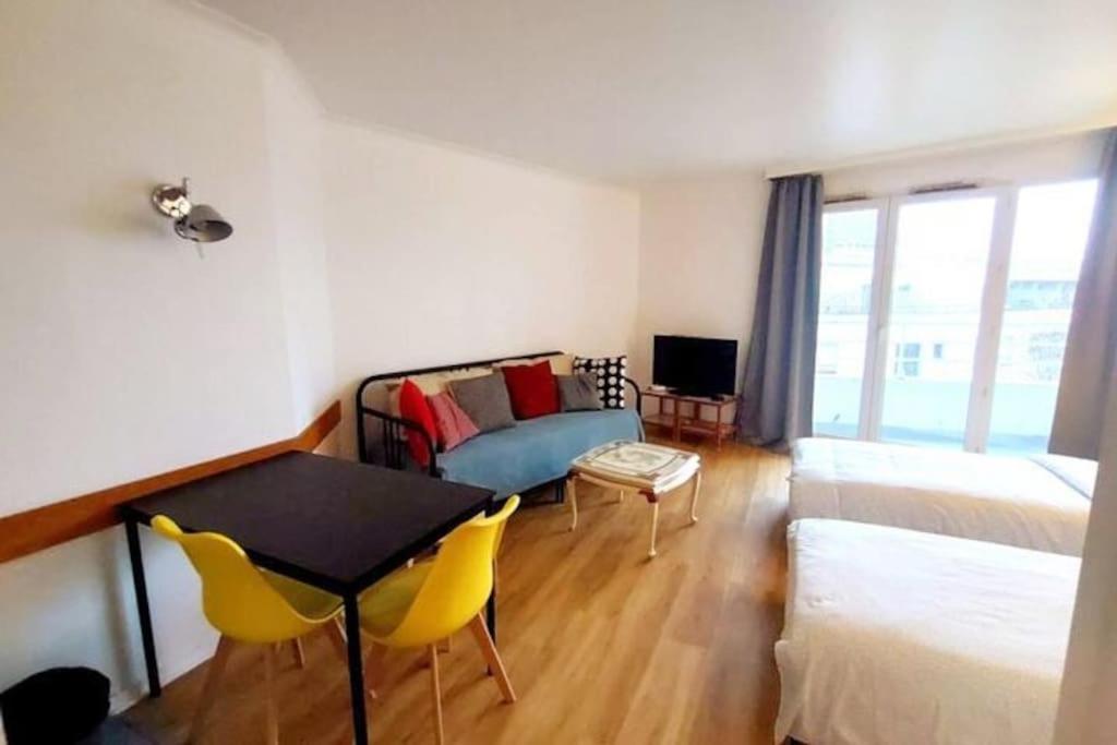 une chambre avec un lit, une table et des chaises dans l'établissement 7mn walk to Metro, in ApartHotel, à Courbevoie