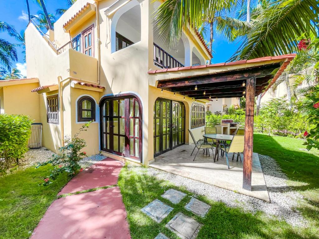 ein Haus mit einer Terrasse und einem Tisch im Hof in der Unterkunft Garden & Ocean View VILLAS & Apartments WiFi BBQ Beach CLUB & SPA in Punta Cana