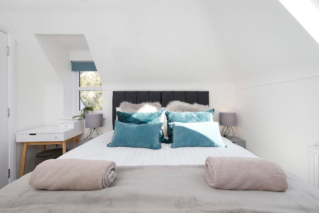 a bedroom with a large bed with blue pillows at Nightingale - Perfect location close to the Beach - Free Parking in Bournemouth