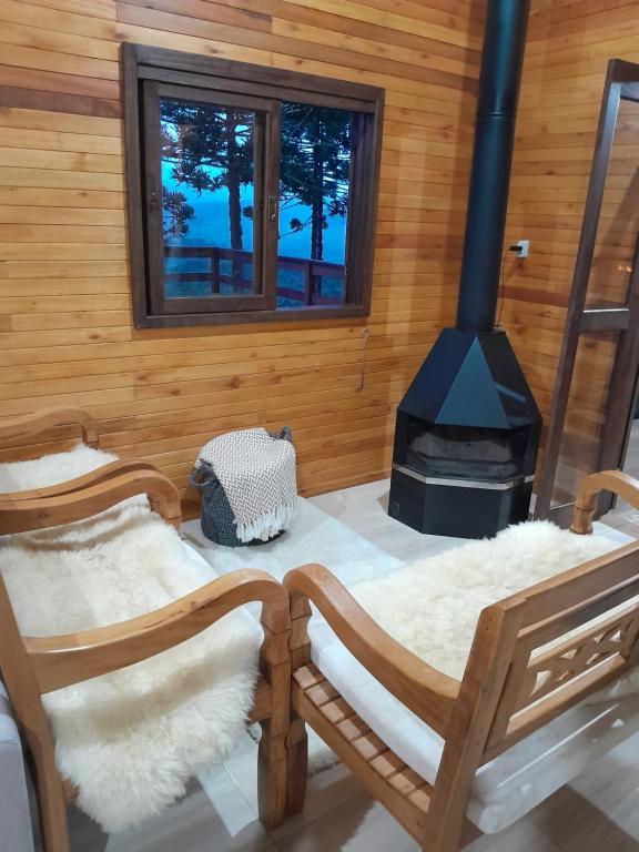 a room with two chairs and a stove at casa dos sonhos in Bom Jardim da Serra