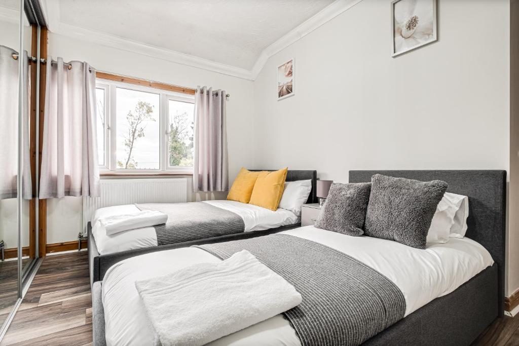 a bedroom with two beds and a window at Comfortable and Spacious Home - Free Parking in Bedford
