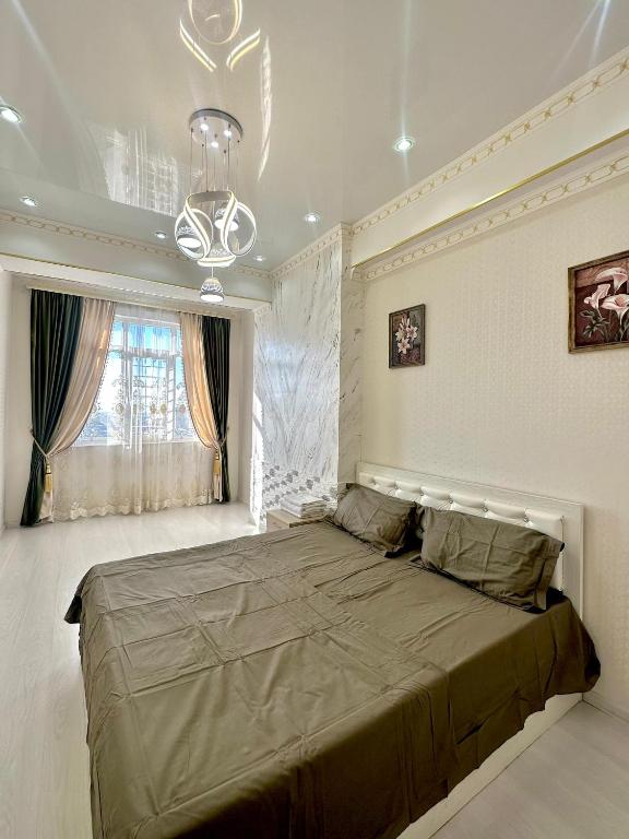 Двухкомнатная элитка Ала-Арча في بيشكيك: غرفة نوم بسرير كبير ونافذة