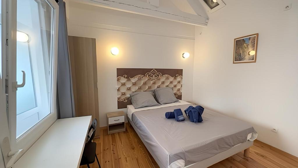 um pequeno quarto com uma cama e uma janela em FRGK "Villa Oasis Urbain" em Cannes