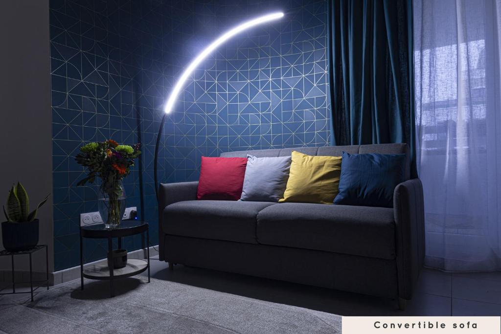 ein Wohnzimmer mit einem Sofa und bunten Kissen in der Unterkunft Appartement cosy aux portes de Disney in Chessy